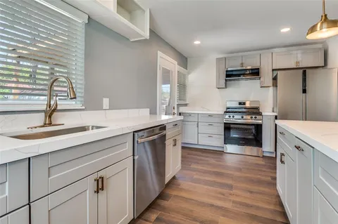 a kitchen with stainless steel appliances granite countertop a sink stove and refrigerator