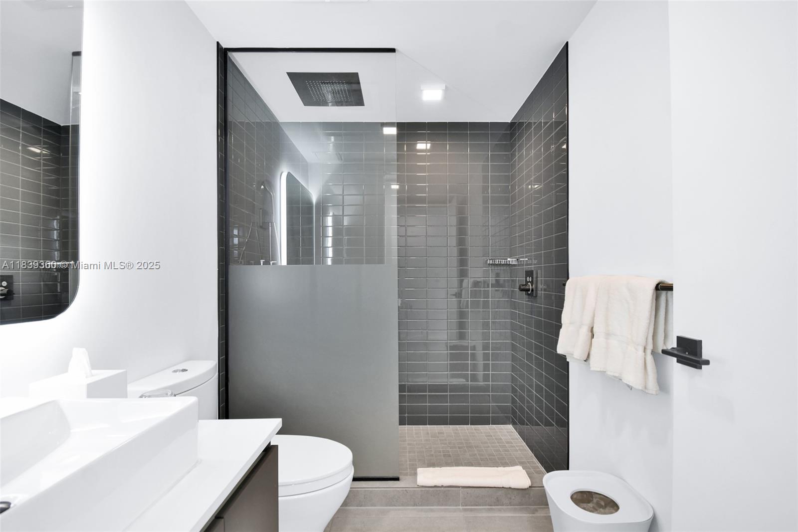 227 Northeast 2nd Street, Unit 2000 Miami, FL 33132 - Photo 21 of 44 a bathroom with a shower and a toilet