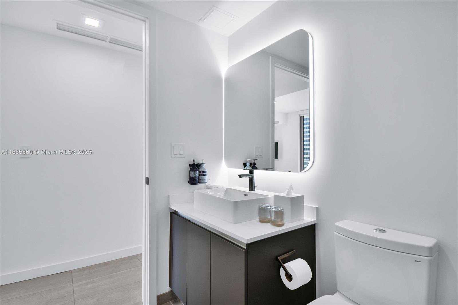 227 Northeast 2nd Street, Unit 2000 Miami, FL 33132 - Photo 22 of 44 a bathroom with a toilet sink and mirror