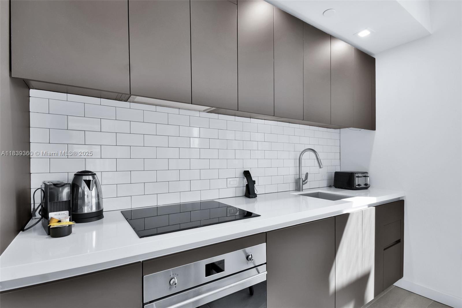 227 Northeast 2nd Street, Unit 2000 Miami, FL 33132 - Photo 10 of 44 a kitchen with a sink and cabinets