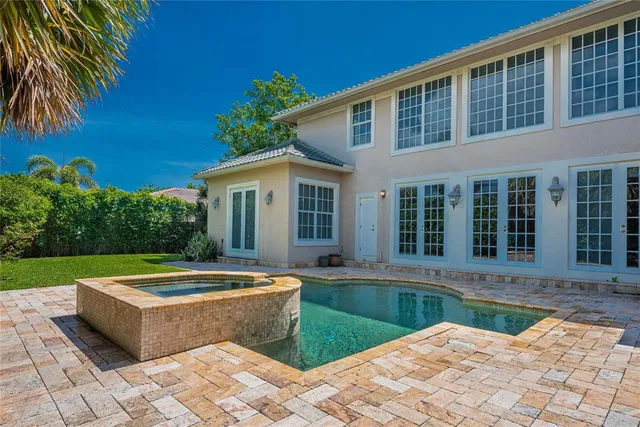 a view of a house with pool and a yard