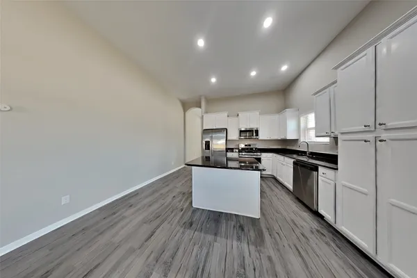 a kitchen with granite countertop white cabinets and white appliances