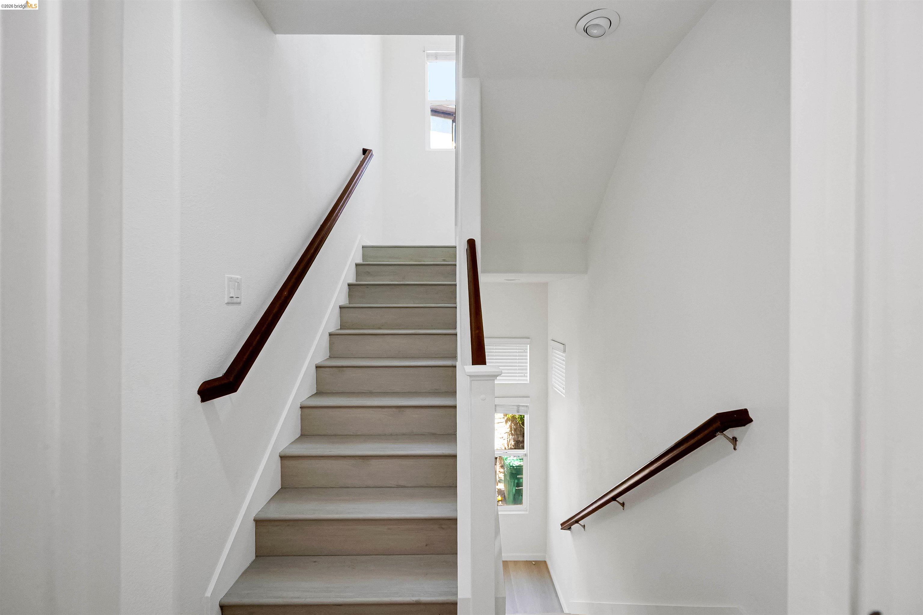 449 Constantine Court San Ramon, CA 94583 - Photo 34 of 63 Multi-level interior featuring light wood-finish stair treads with dark wood handrails, recessed ceiling lighting, and crisp white wall finishes
