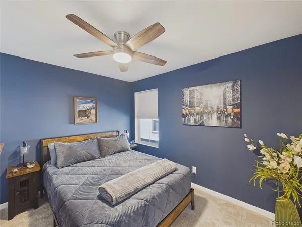 a bedroom with a bed and painting on the wall