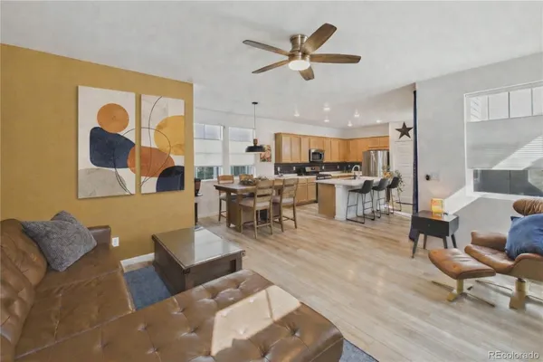 a living room with stainless steel appliances furniture and a large window