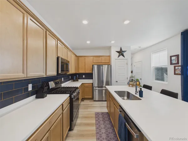 a kitchen with a sink a counter top space stainless steel appliances and cabinets
