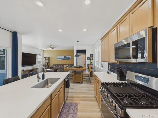 a kitchen with sink stove and refrigerator