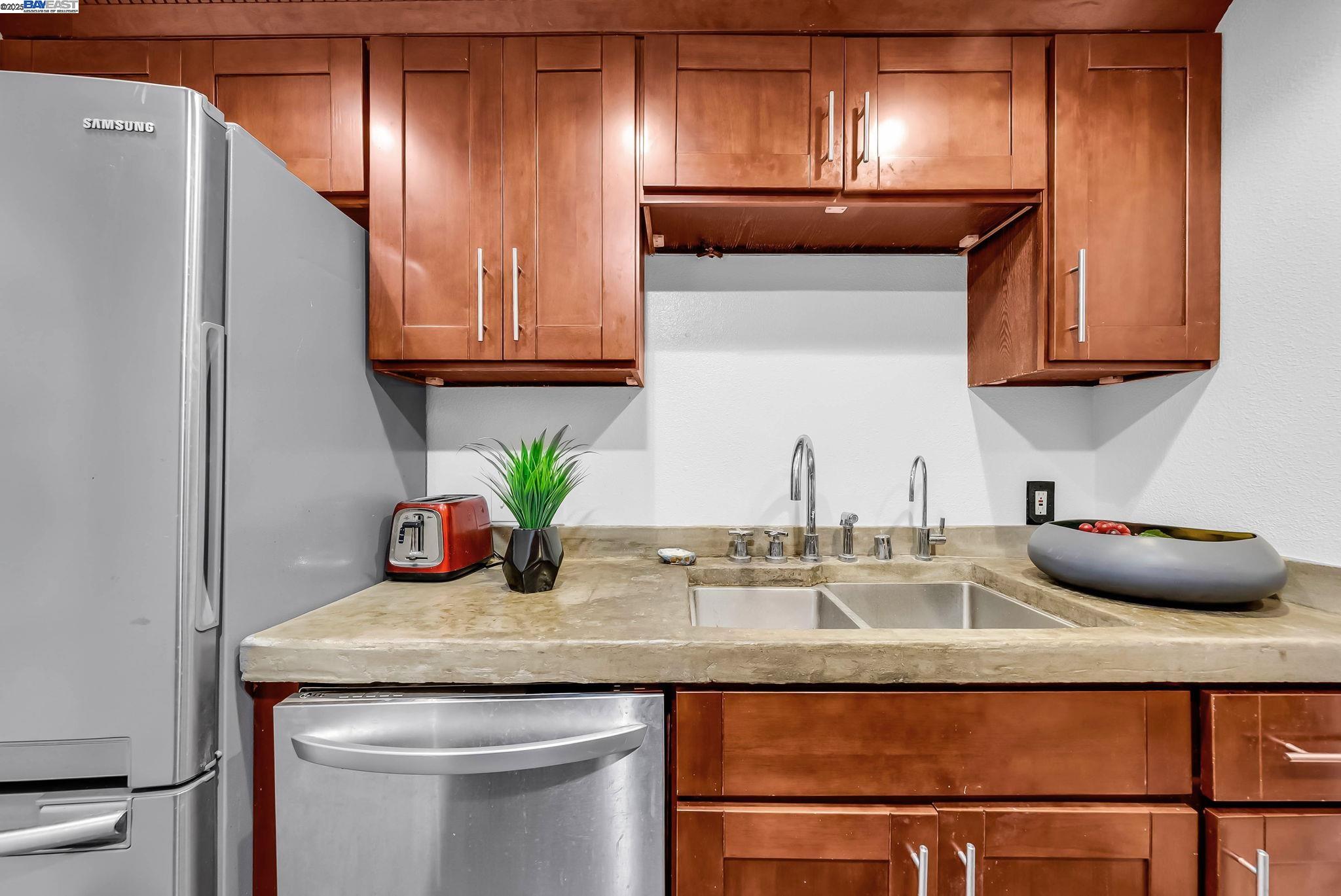 400 Wayne Avenue, Unit 1 Oakland, CA 94606 - Photo 18 of 37 a kitchen with granite countertop stainless steel appliances and wooden cabinets