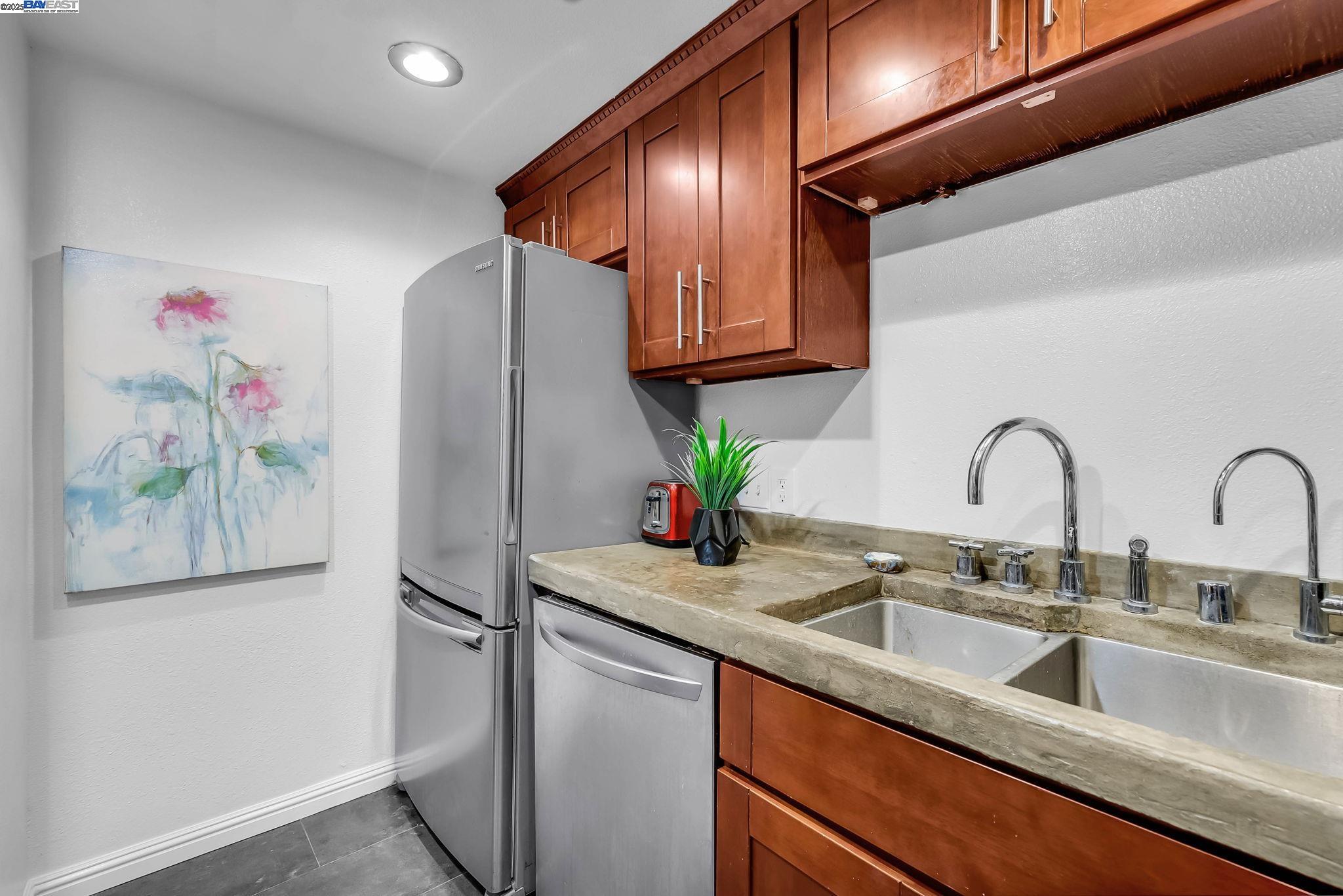 400 Wayne Avenue, Unit 1 Oakland, CA 94606 - Photo 19 of 37 a kitchen with stainless steel appliances granite countertop a sink and a refrigerator