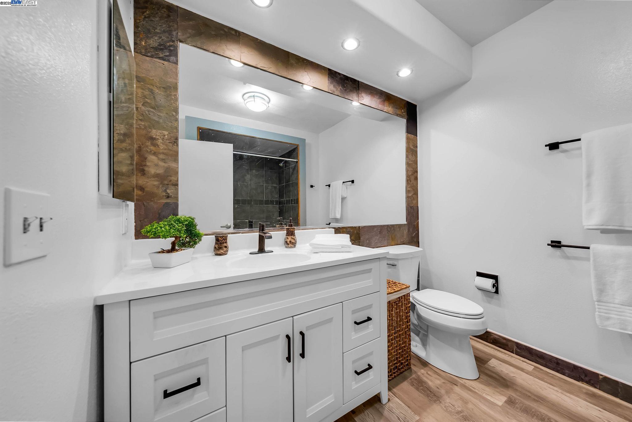 400 Wayne Avenue, Unit 1 Oakland, CA 94606 - Photo 23 of 37 a bathroom with a toilet sink and mirror