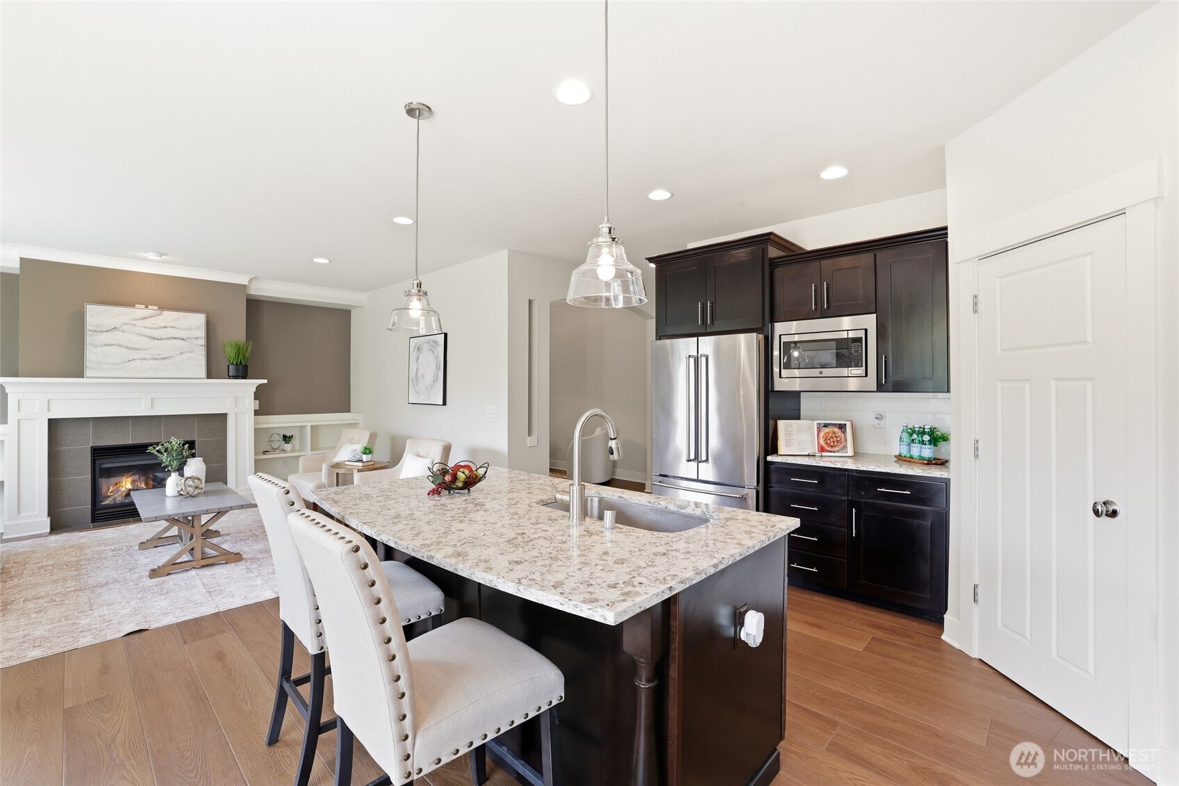 16927 35th Drive Southeast Bothell, WA 98012 - Photo 11 of 38 a kitchen with kitchen island a stove a refrigerator a sink a dining table and chairs with wooden floor
