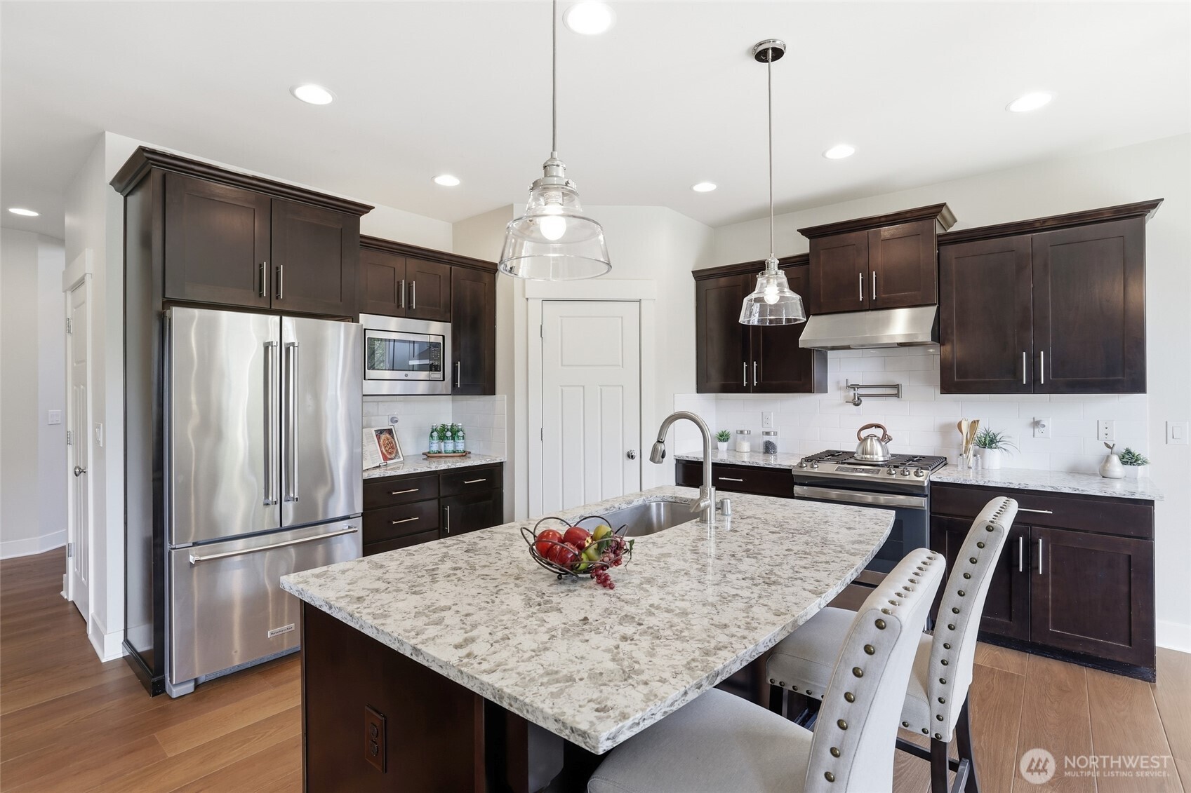 16927 35th Drive Southeast Bothell, WA 98012 - Photo 10 of 38 a kitchen with granite countertop a refrigerator a stove a sink a dining table and chairs
