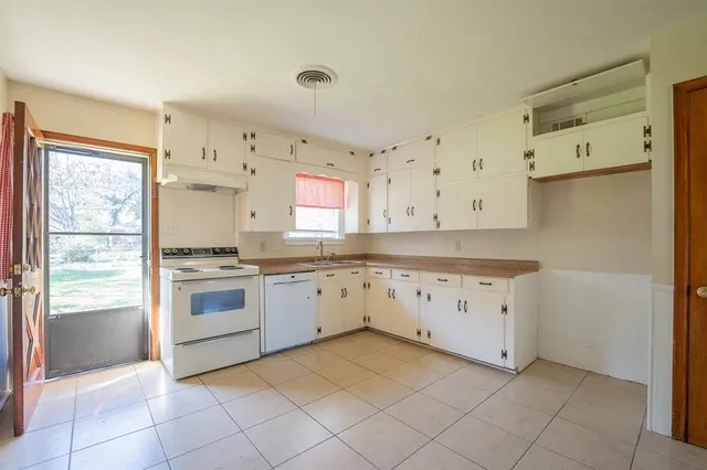 a kitchen with granite countertop white cabinets and white appliances