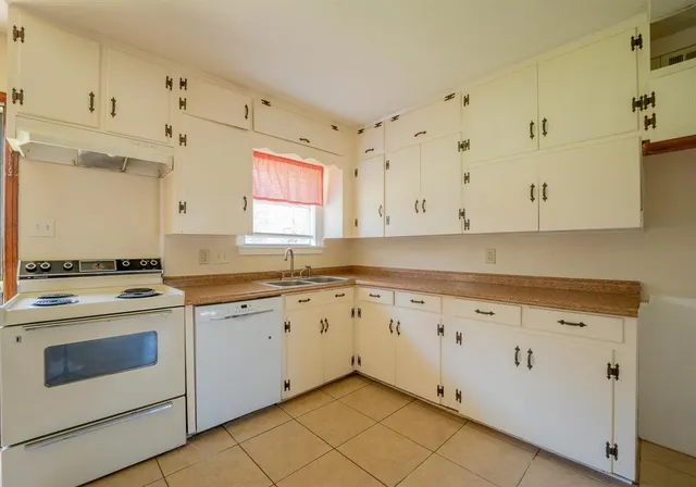 a kitchen with granite countertop white cabinets and white appliances