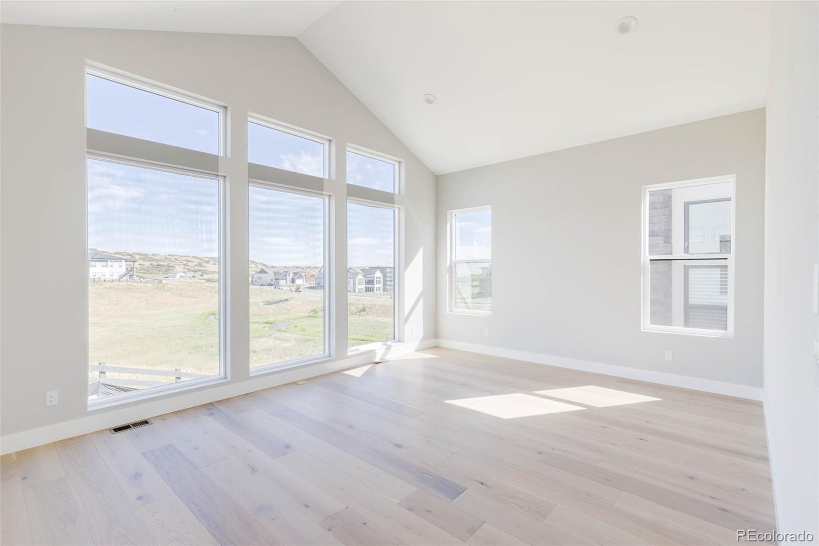 2233 Rim Ridge Drive Castle Pines, CO 80108 - Photo 19 of 40 a view of an empty room with wooden floor and a window