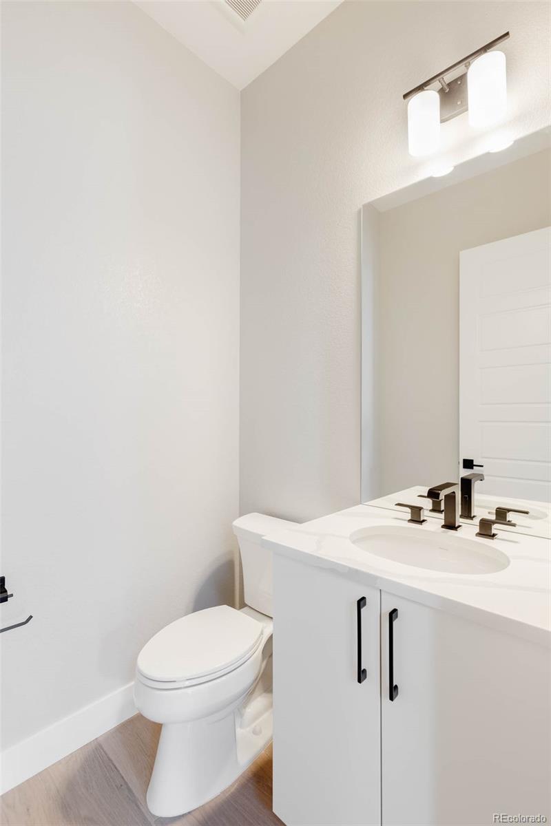 2233 Rim Ridge Drive Castle Pines, CO 80108 - Photo 26 of 40 a bathroom with a sink a toilet and mirror