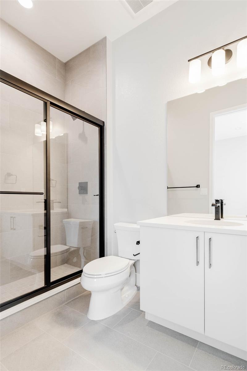 2233 Rim Ridge Drive Castle Pines, CO 80108 - Photo 29 of 40 a bathroom with a shower a toilet and a sink
