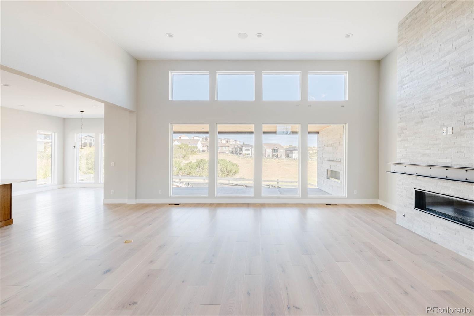 2233 Rim Ridge Drive Castle Pines, CO 80108 - Photo 9 of 40 a view of an empty room with wooden floor and a window