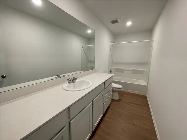 a bathroom with a sink a toilet and a large mirror