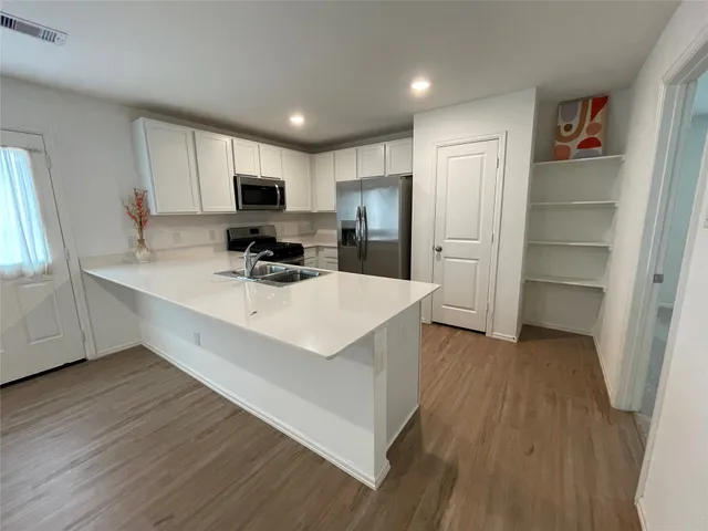 a kitchen with stainless steel appliances a sink stove and refrigerator