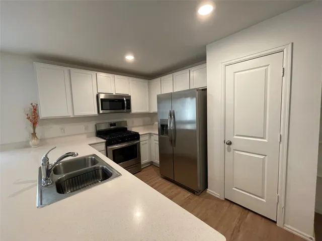 a kitchen with stainless steel appliances a refrigerator a stove a microwave and cabinets