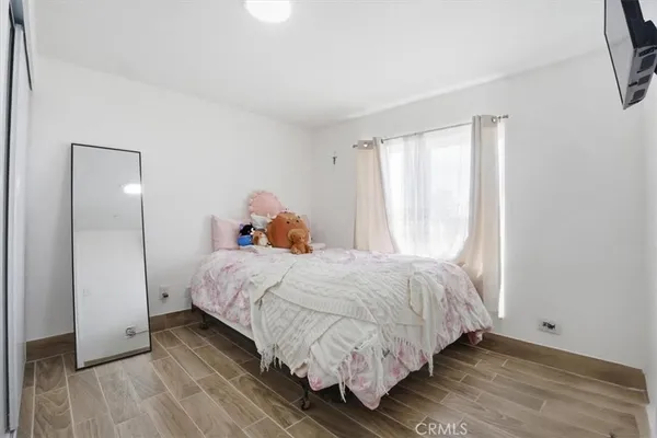 a bedroom with a bed and wooden floor