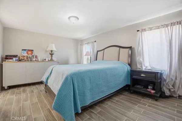 a bedroom with a bed and a mirror on dresser