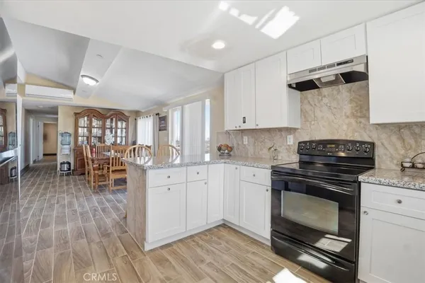 a kitchen with granite countertop cabinets stainless steel appliances and dining table