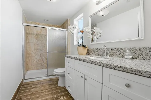 a bathroom with a granite countertop sink toilet and shower