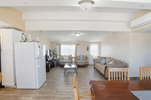 a living room with furniture and a refrigerator