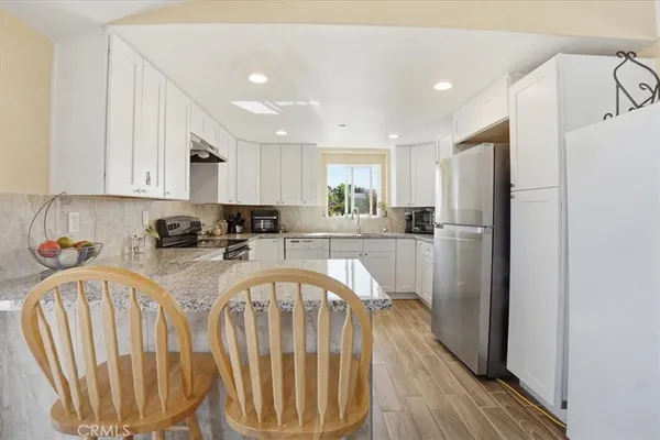 a kitchen with stainless steel appliances granite countertop a refrigerator sink and cabinets
