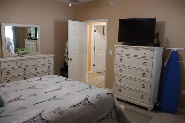 a bedroom with a bed and a flat screen tv in white walls