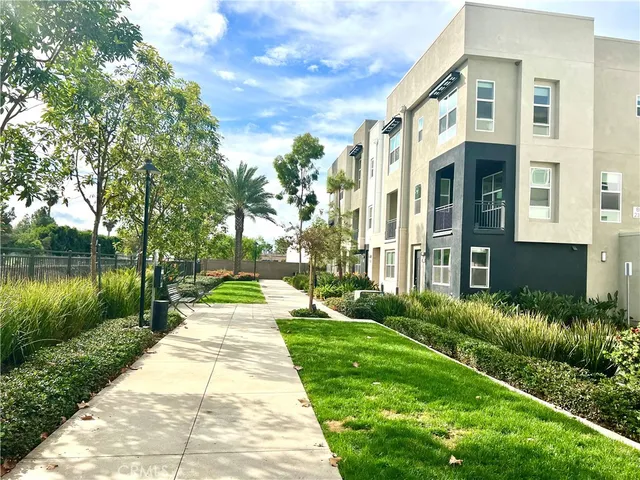 a view of a brick house with a yard and plants