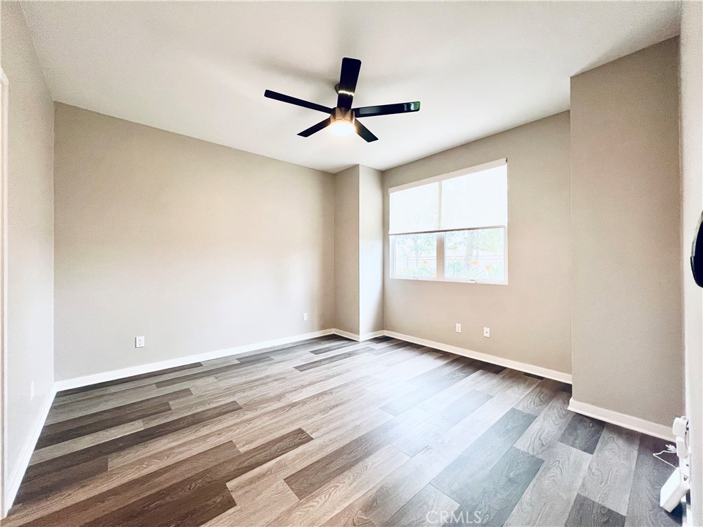 2336 Synergy Irvine, CA 92614 - Photo 11 of 24 an empty room with wooden floor ceiling fan and windows