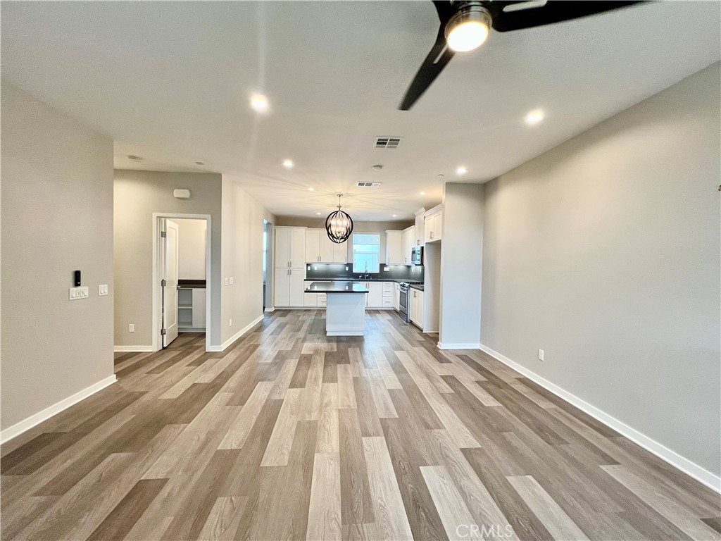 2336 Synergy Irvine, CA 92614 - Photo 12 of 24 a view of a kitchen with kitchen island white cabinetry and a chandelier