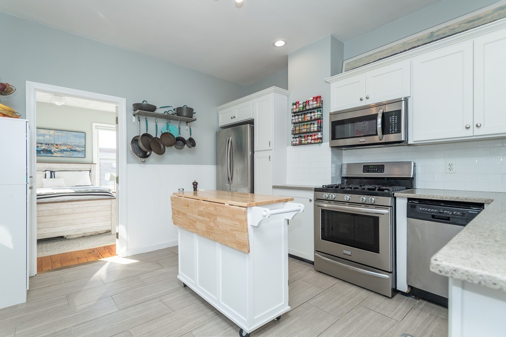 23-23A Sullivan Street, Unit 3 Boston, MA 02129 - Photo 4 of 8 a kitchen with stainless steel appliances granite countertop a stove and a microwave