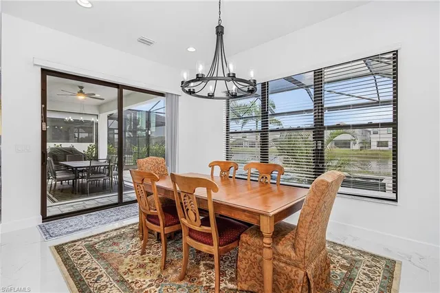 a dining room with furniture a chandelier and wooden floor