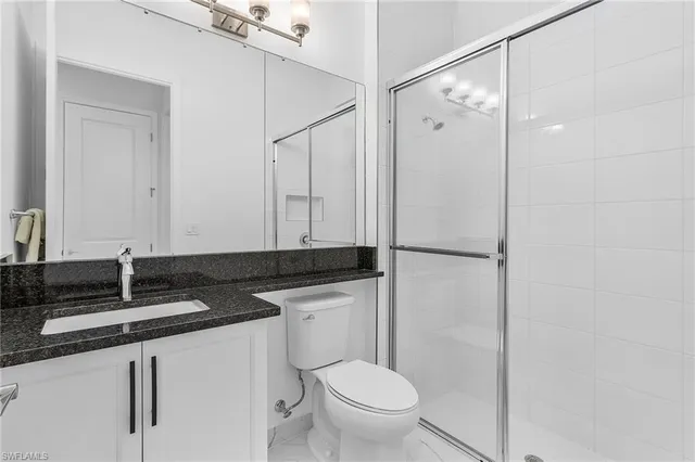 a bathroom with a granite countertop sink toilet and shower