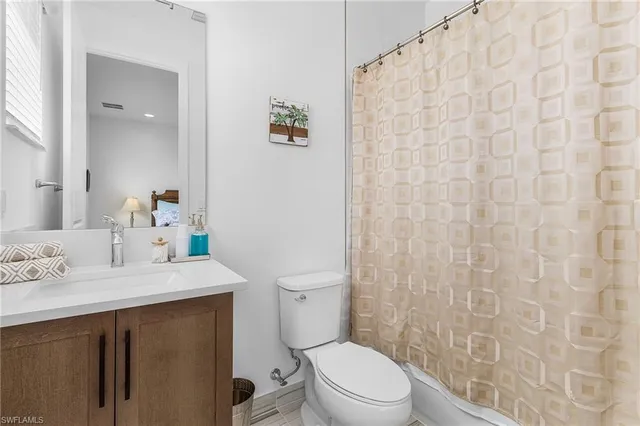 a view of a white house with a yard and potted plants