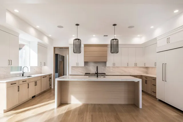 a large kitchen with kitchen island a sink stainless steel appliances and cabinets