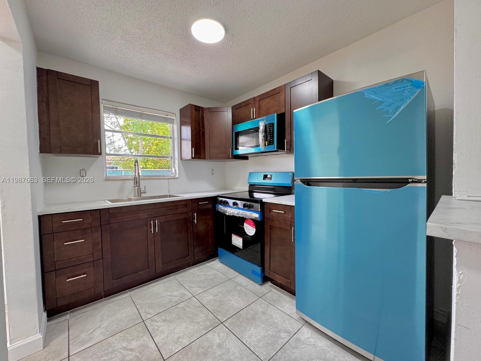 3630 Southwest 87th Avenue Miami, FL 33165 - Photo 5 of 14 a kitchen with a refrigerator and a sink