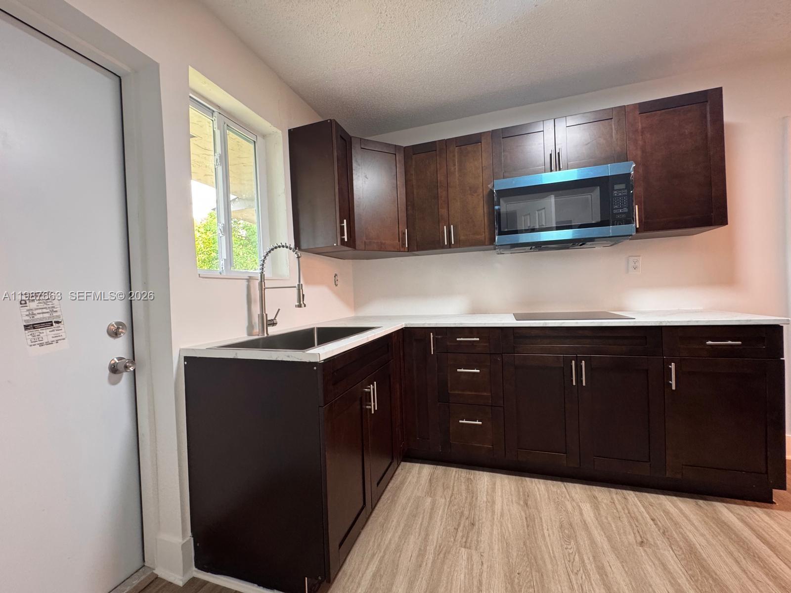 3630 Southwest 87th Avenue Miami, FL 33165 - Photo 7 of 14 a kitchen with wooden cabinets and a sink