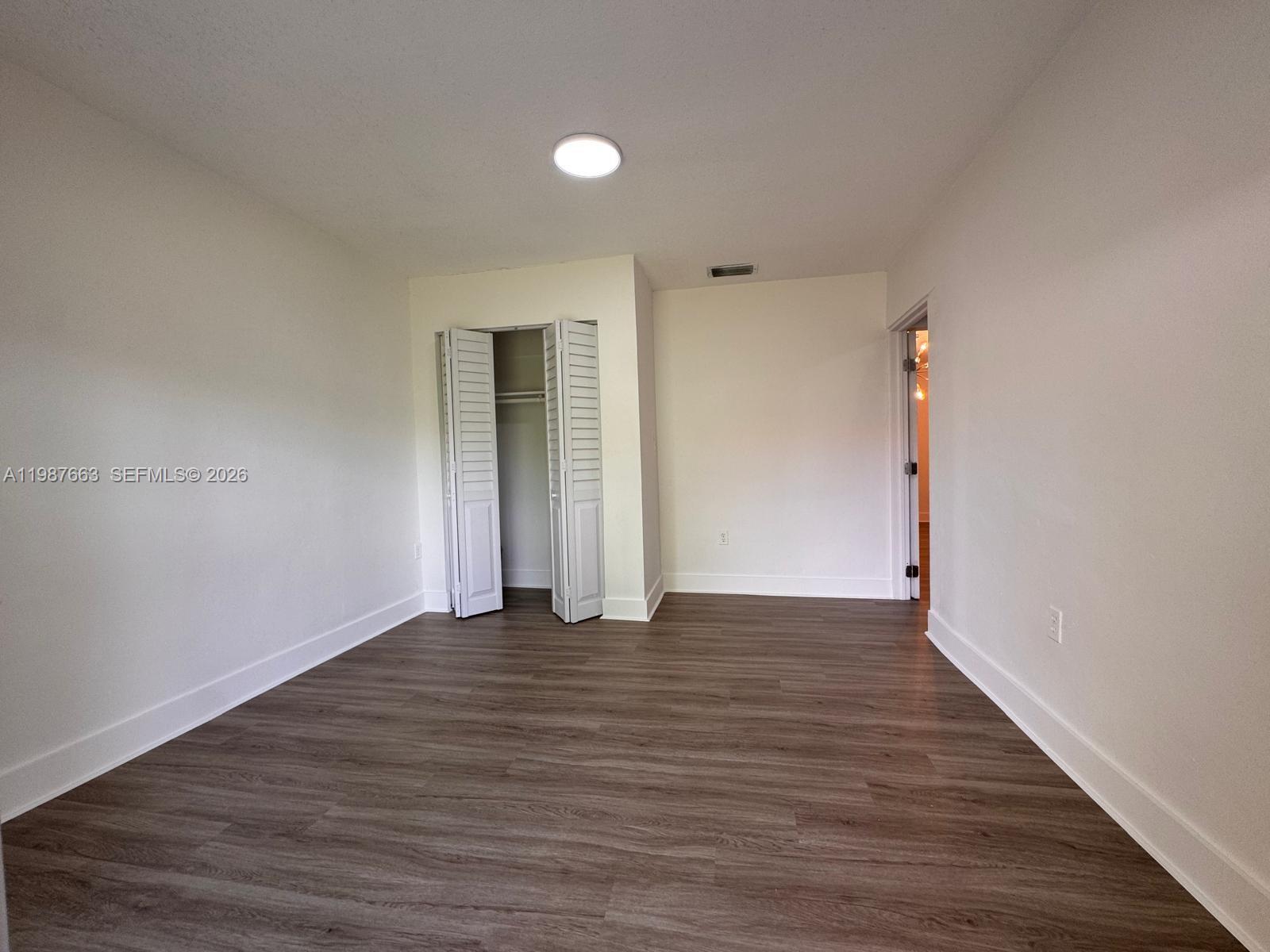 3630 Southwest 87th Avenue Miami, FL 33165 - Photo 8 of 14 a view of an empty room with wooden floor