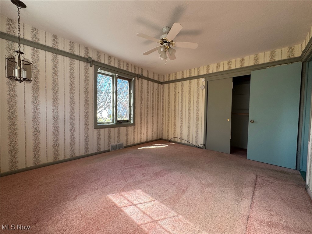 725 Pendley Road Willowick, OH 44095 - Photo 15 of 36 Main bedroom featuring carpet floors, a ceiling fan, wallpapered walls, and a double closet