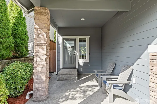 a patio with table and chairs and potted plants