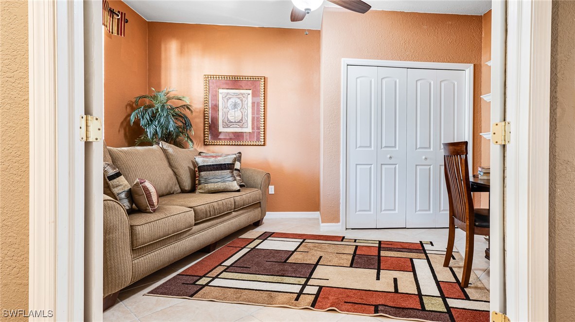 14801 Reflection Key Circle, Unit 212 Fort Myers, FL 33907 - Photo 3 of 33 a living room with a couch and a potted plant next to a window