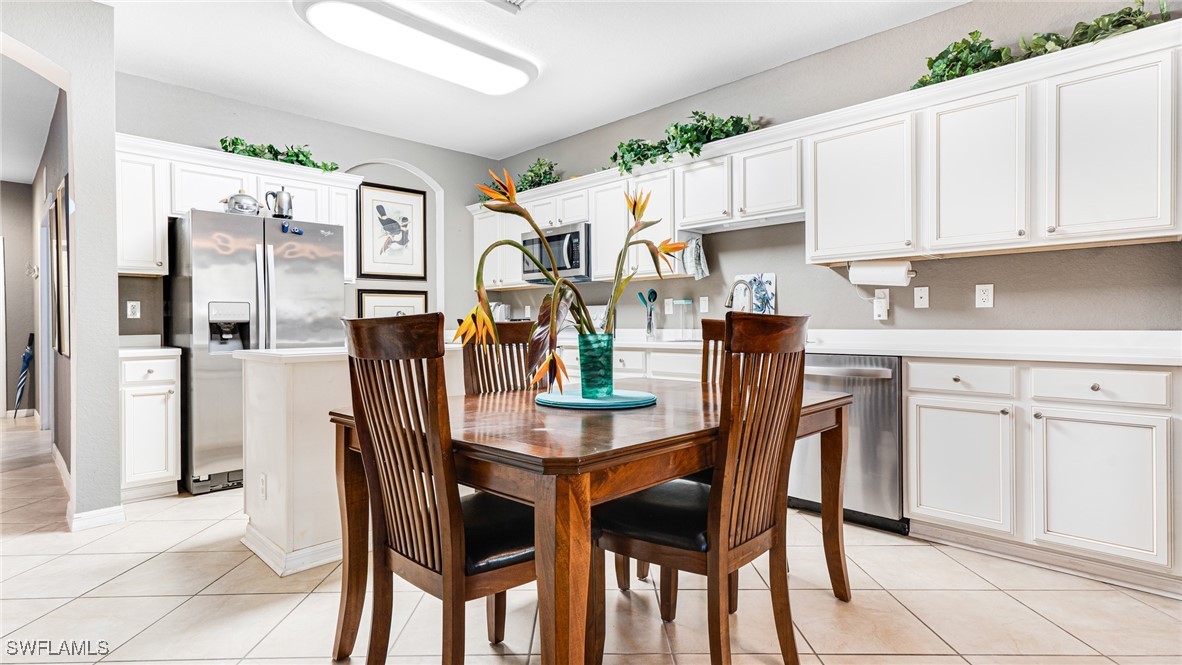 14801 Reflection Key Circle, Unit 212 Fort Myers, FL 33907 - Photo 9 of 33 a dining area with stainless steel appliances kitchen island granite countertop a table and chairs