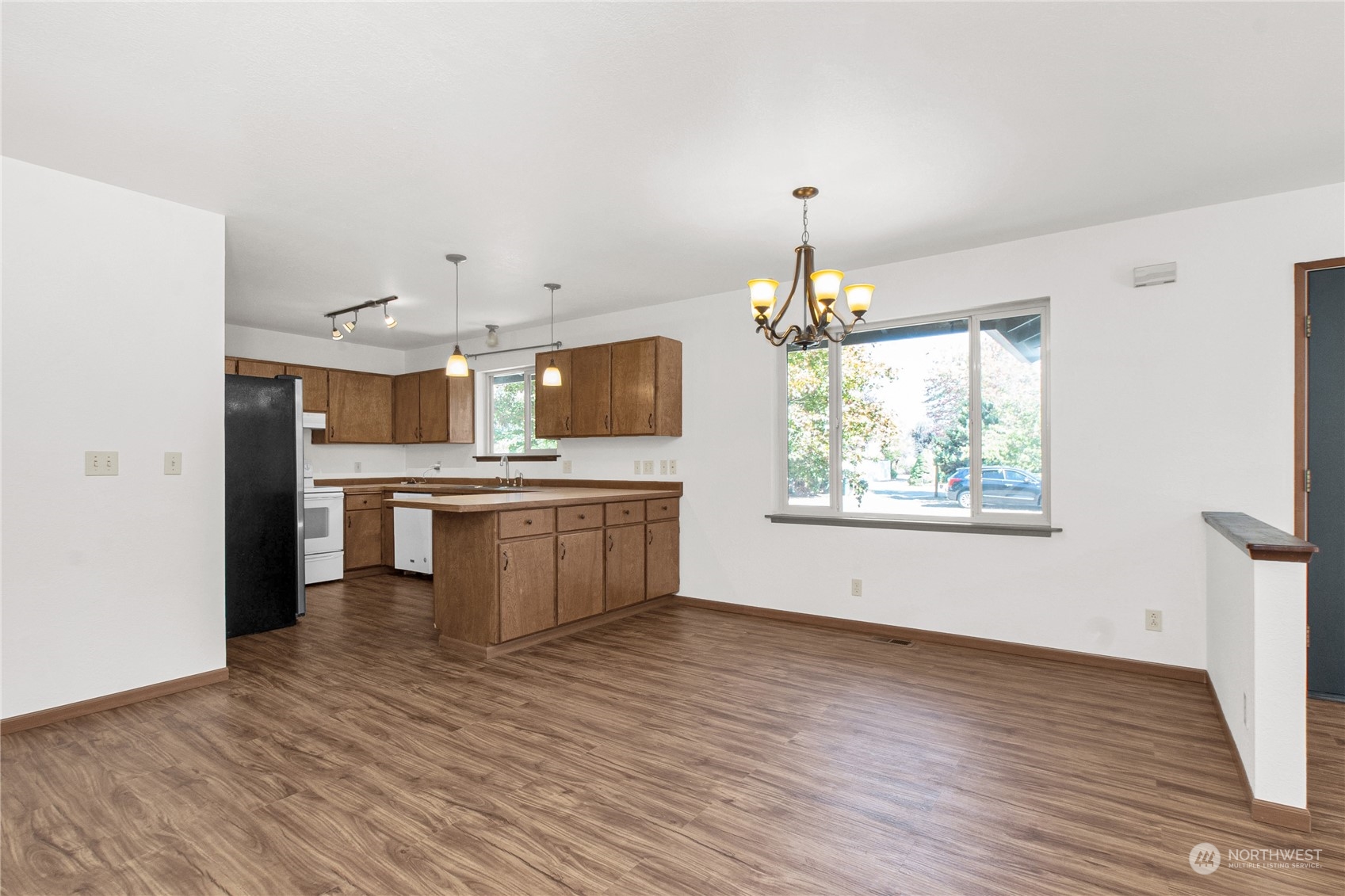 16635 Case Road Southwest Rochester, WA 98579 - Photo 9 of 35 a large white kitchen with a stove a sink dishwasher and a refrigerator with wooden floor