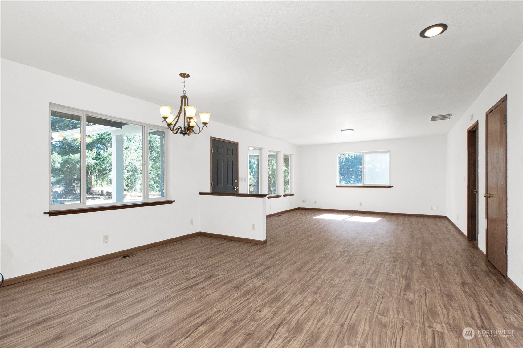 16635 Case Road Southwest Rochester, WA 98579 - Photo 10 of 35 an empty room with wooden floor chandelier and windows