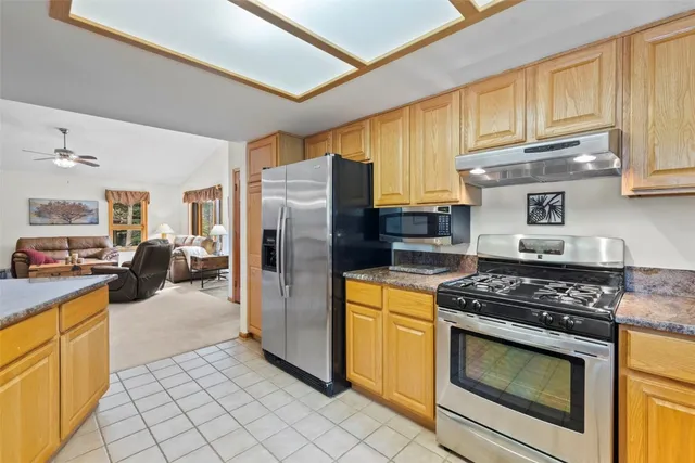 a kitchen with stainless steel appliances granite countertop a stove a refrigerator and a sink